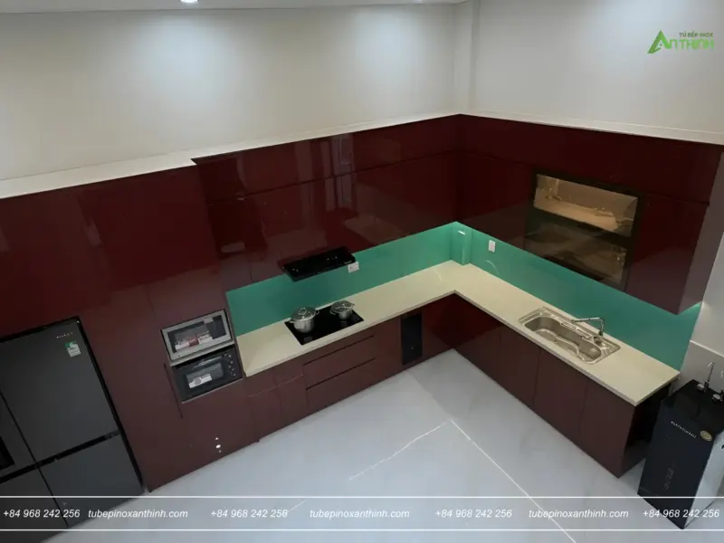Góc nhìn tổng thể tủ bếp chữ L acrylic bóng gương đỏ rượu tại Gia Đình Chị Giang ở Đan Phượng, Hà Nội