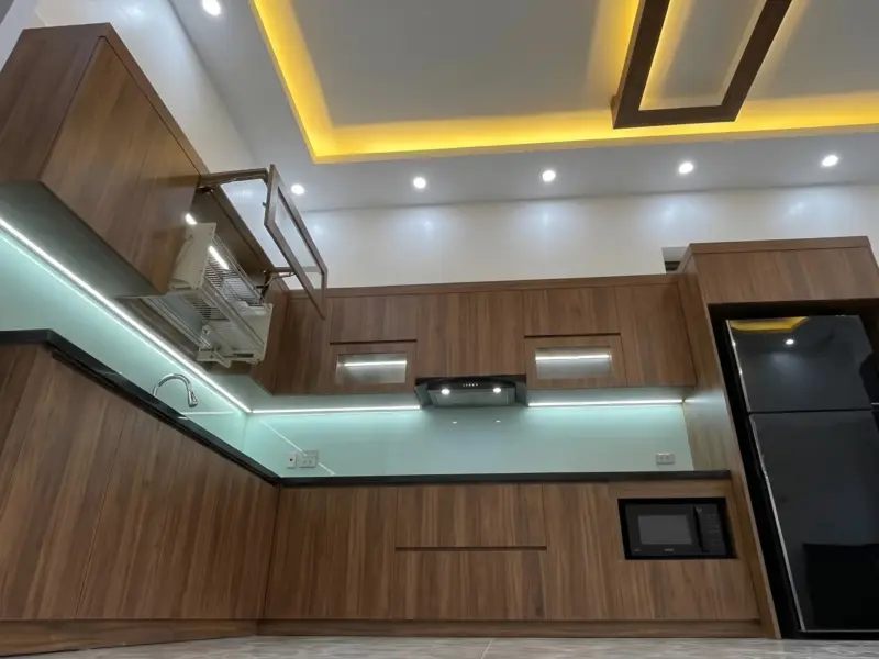 Góc nhìn từ thấp lên hệ tủ trên và trần nhà của công trình tủ Bếp Cánh Gỗ Nhựa Chống Nước Phủ Melamine Cho Gia Đình Anh Khánh tại Yên Nghĩa, Hà Nội