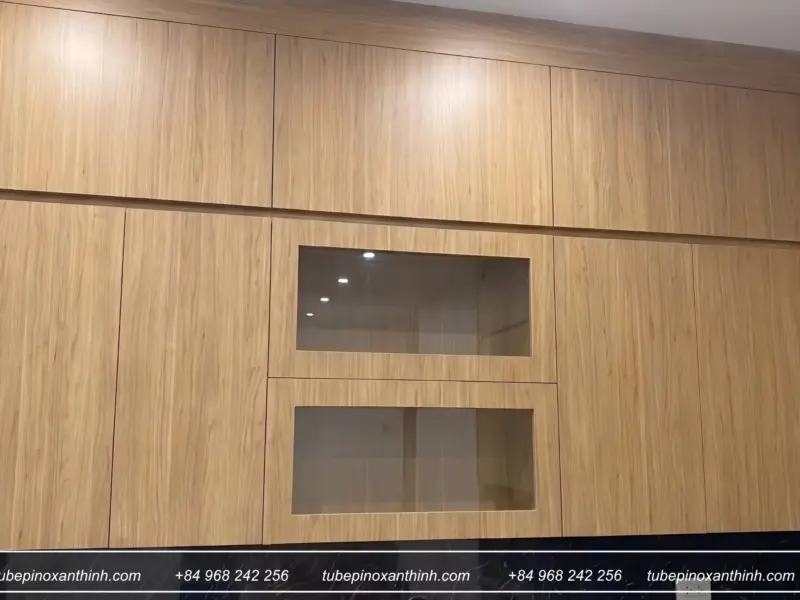 Tủ bếp Inox 304 cánh gỗ MDF chống ẩm phủ Melamine – góc tủ trên kính tại nhà chị Hương ở Hoài Đức, Hà Nội