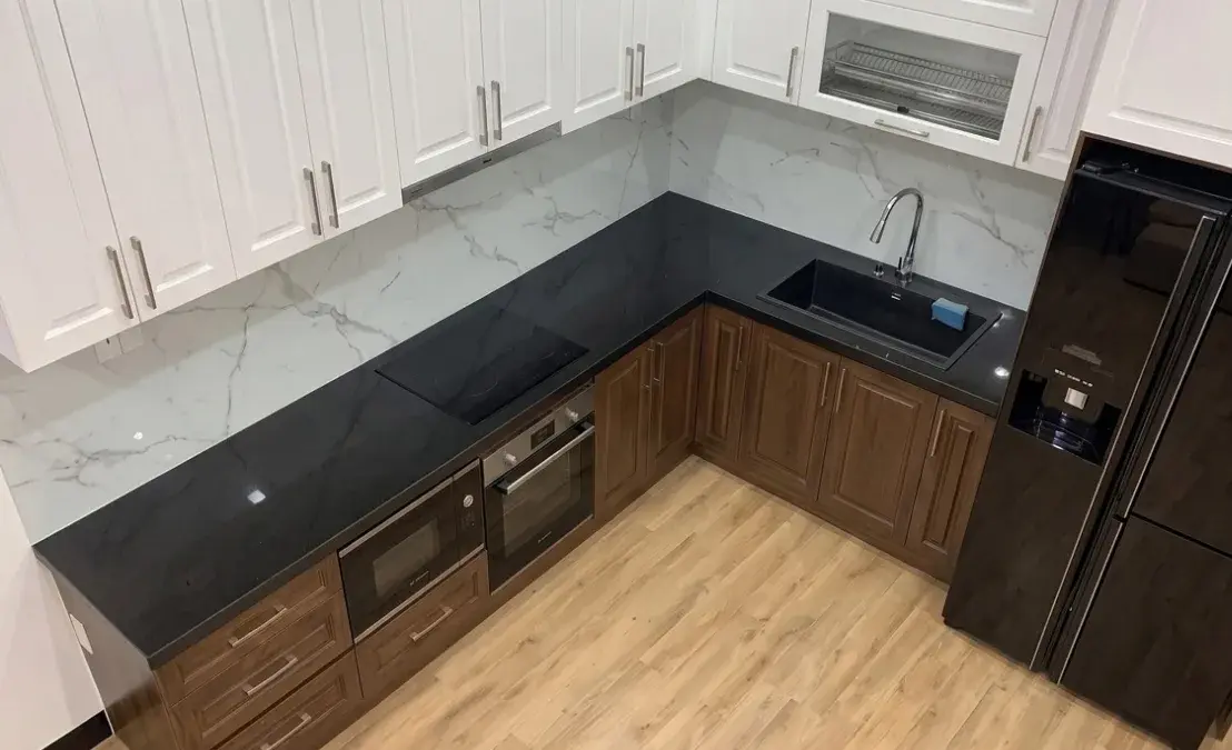 Góc bếp chữ L với mặt đá đen và tủ dưới gỗ óc chó tại Gia Đình Chị Dung ở Ba Đình, Hà Nội